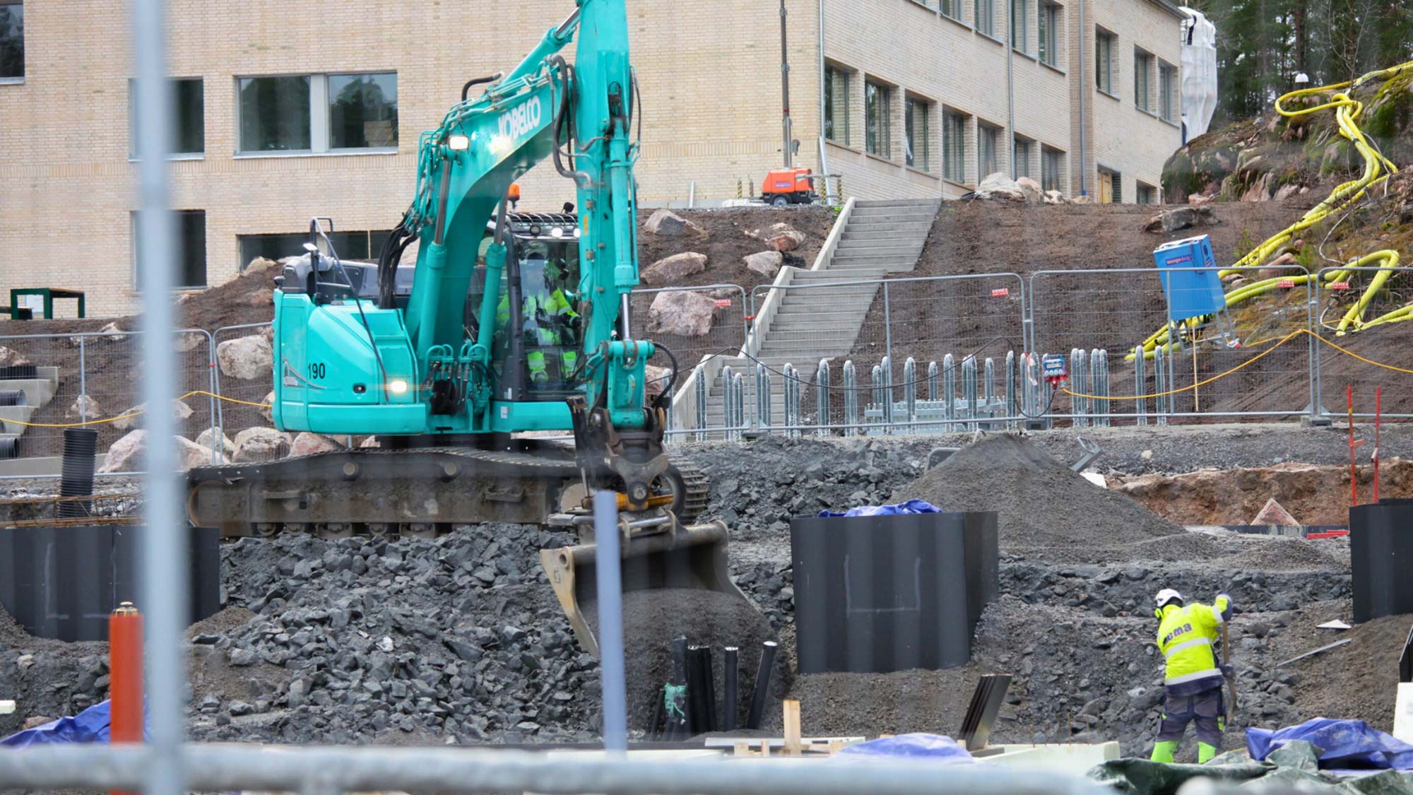 Grävskopa och en MEMA medarbetare